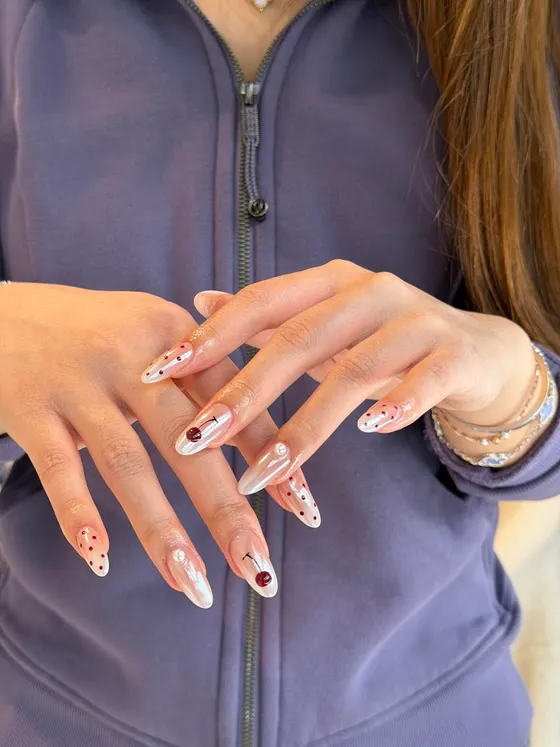Pearl-chrome almond nails with cherry detail at Soso Beauty